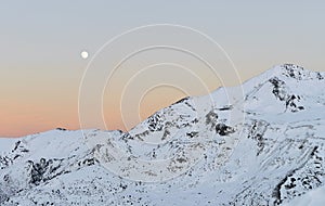 Landscape of snowy mountains, with the moon