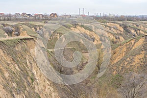 Landscape with soil erosion and flowering apricot trees in loamy ravines near Dnipro city, Ukraine photo