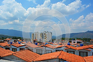 A landscape of some houses seen from the roof with a blue sky in the background photo