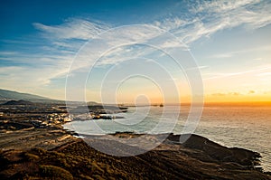 Landscape of the south coast of Tenerife. Scenic sunrise over the beach and sea. Red mountain viewpoint. Canary Islands