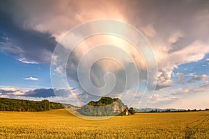 Landscape with dramatic sky and rainbow.