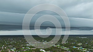 Landscape of stormy sky over North Port town with tarp covered roofs after hurricane Ean swept through Florida with dark