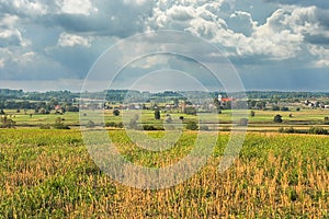 Landscape in summer with blue sky and clouds with bright sun in the background