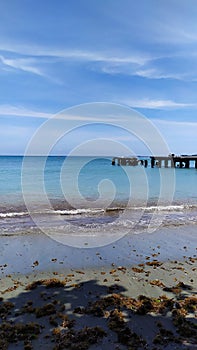 A landscape of a sunny beach with a bridge. Un paisaje de una playa soleada con puente photo