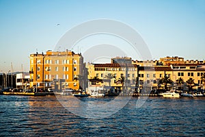 Landscape at sunset with the buildings on the other side of the city and boats