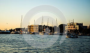 Landscape at sunset with the buildings on the other side of the city and boats