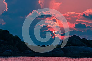 Landscape of sunset with dramatic sky and rock island and sea.