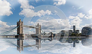 Landscape of Tower Bridge in London, with a nice water reflection and blue cloudy sky