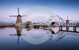 Landscape with traditional dutch windmills and drawbridge at sunrise