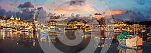 Landscape with traditional Luzzu boat in harbor of Marsaxlokk, Malta