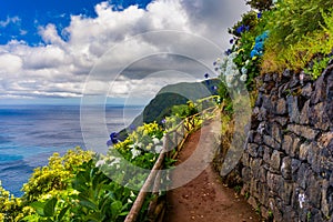 Landscape with trail looking from Miradouro da Ponta do Sossego in direction of Ponta da Madrugada on a sunny day, Sao Miguel. photo