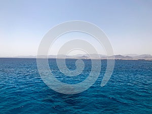 Landscape of transparent blue periling sea salt water, sea, ocean with waves, ripples under the scorching sun against the backdrop