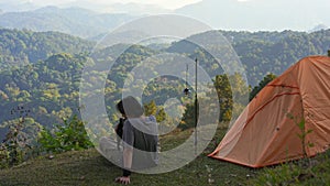 landscape and travel with solo freelancer man camping work outdoor and play with cat with layer of mountain background