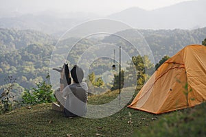 landscape and travel with solo freelancer man relax and play with cat and see sunset with layer of mountain