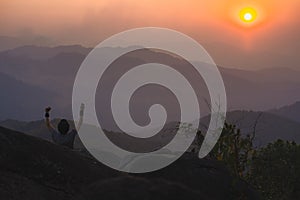 landscape and travel with solo freelancer man relax at top of mountain and sunset with layer of mountain