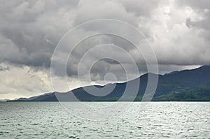 Landscape with tropical sea, monsoon storm heavy clouds and tropical Koh Chang island on horizon in Thailand