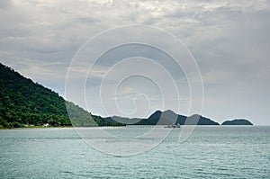 Landscape with turquoise tropical sea, monsoon storm heavy clouds and tropical Koh Chang island on horizon in Thailand