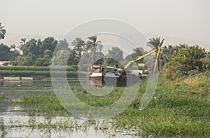 Landscape view across african river with dredging barge