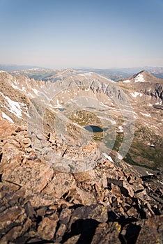 Landscape view of alpine lake surrounded by mountains from the top of Quandary Peak in Colorado.