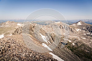 Landscape view of alpine lake surrounded by mountains from the top of Quandary Peak in Colorado.