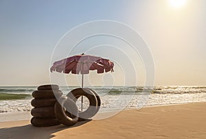 Landscape view beach umbrella with ring lifebuoys on tropical sandy beach in the sunset time