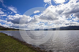 Landscape view of a beautiful clean lake under a blue cloudy sky on a sunny day