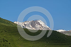 Landscape view of beautiful mountain valley in summer sunny day at Stepantsminda, Kazbegi city, Georgia. Green Mountains