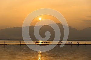Landscape view - boatman paddle boat in the lagoon lake.Kwan phayao in evenign time at phayao thailand