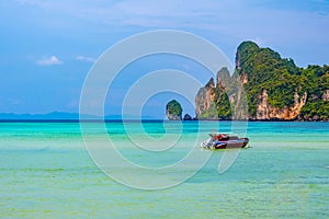 Landscape view of coastline with limestone rock and boats on ocean at Ko Phi Phi islands, Thailand. Concept of exotic tropical