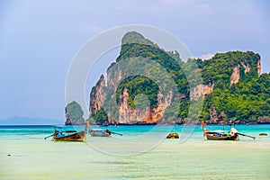 Landscape view of coastline with limestone rock and boats on ocean at Ko Phi Phi islands, Thailand. Concept of exotic tropical