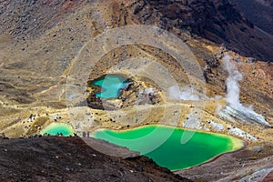 Landscape view of colorful Emerald lakes and volcanic landscape with hikers walking by, Tongariro national park, New Zealand