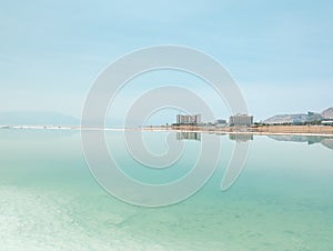 Landscape view on Dead Sea salt crystals formations, clear cyan green water at Ein Bokek beach, Israel