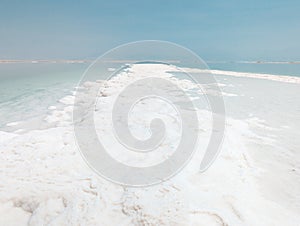 Landscape view on Dead Sea salt crystals formations, clear cyan green water at Ein Bokek beach, Israel