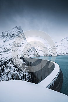 Landscape view on the Emosson dam and lake, sourrounded by mountain ranges covered by snow