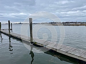 Landscape view of an empty wooden pier in Norwalk harbor on an overcast day photo