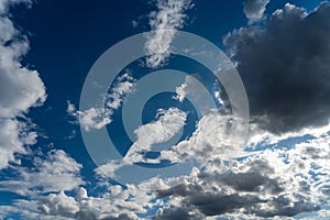 A Landscape view of the fluffy white and grey clouds in sunny blue sky