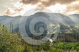 Landscape view with golden rays of the sun breaking through clouds in Tatra mountains