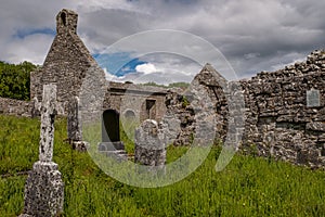 A landscape view through grave stone of the abanoned ruins of Killone Abbey that was built in 1190 and sits on the banks of the