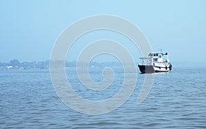 Landscape view of large and heavy rusty cargo container ship on river for transportation of crude oil. International shipment of