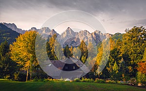 Landscape view of mountain peaks, colorful autumn foliage and cottage, Triglav NP, Slovenia