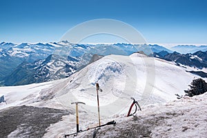 Landscape view of mountains peaks in the Alps. Tree crampons in the front.