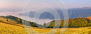 Landscape-view of the mountains at sunrise with sea fog in the v