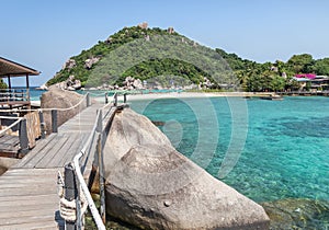 Landscape view of old wooden walkway bridge through the rock at Koh Nang Yuan Island under blue