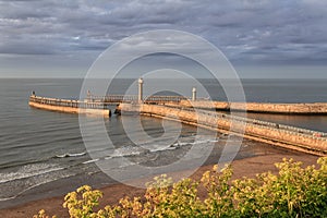 Landscape view of the pier and lighthouse in Whitby