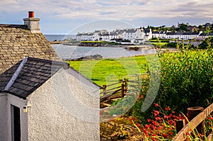 Landscape view of Port Charlotte houses on an ocean coastline, Isle of Islay, Scotland, UK