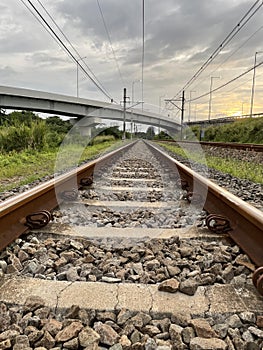Landscape view of railroad tracks leading to infinity and overpass