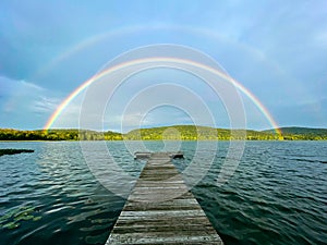 Landscape view of a rainbow over Rockland Lake in Rockland Lake State Park during the golden