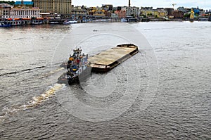 Landscape view of the river barge loaded with sand and two tugboats. Embankment of Dnipro River