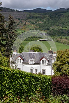 Landscape view of the rolling hills near Aberfeldy, in Highlands, Scotland UK. White painted Bolfracks House in foreground.