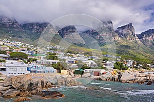 Landscape view of a seaside town along the mountain on a cloudy day in Cape Town, South Africa. Scenic view of a quiet